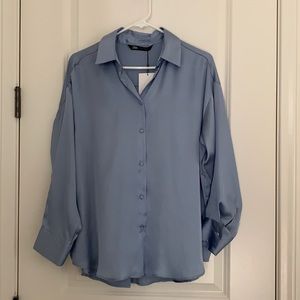 Flowy shirt with lapel collar and long sleeve. Front button closure